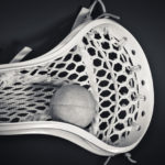 A single lacrosse head with a single ball as a black and white image